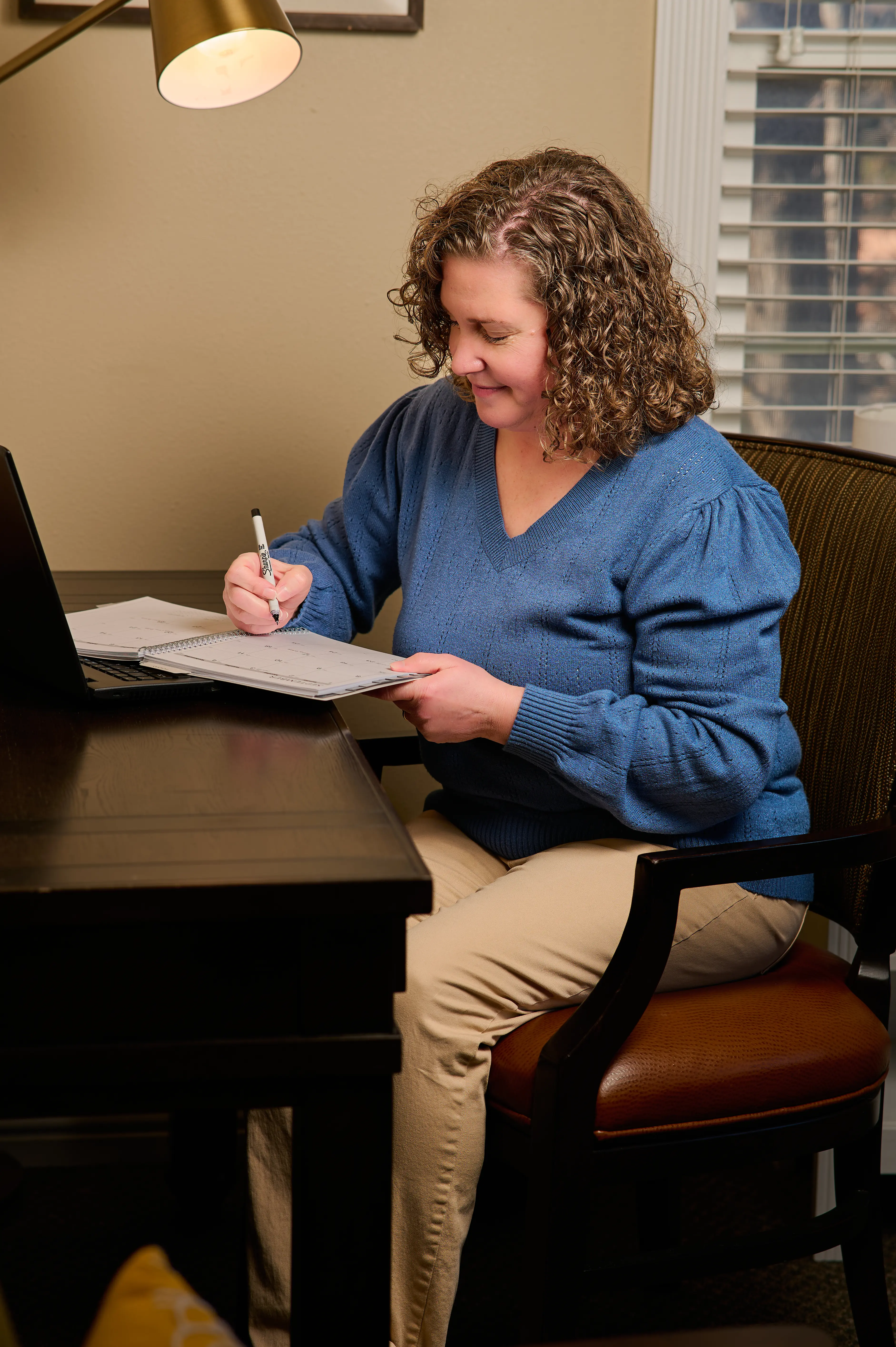 Therapist, Stephanie Heinhold, in her south jordan counseling office taking notes on her recent appointment with a couple who struggle with marital issues