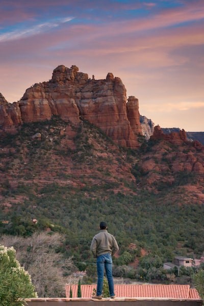 Man standing at red rock. Artist: Gayatri Malhotra. Unsplash